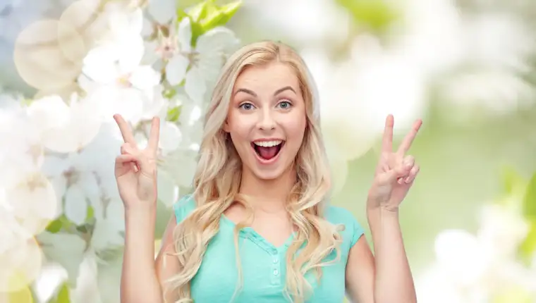 smiling young woman or teenage girl showing peace