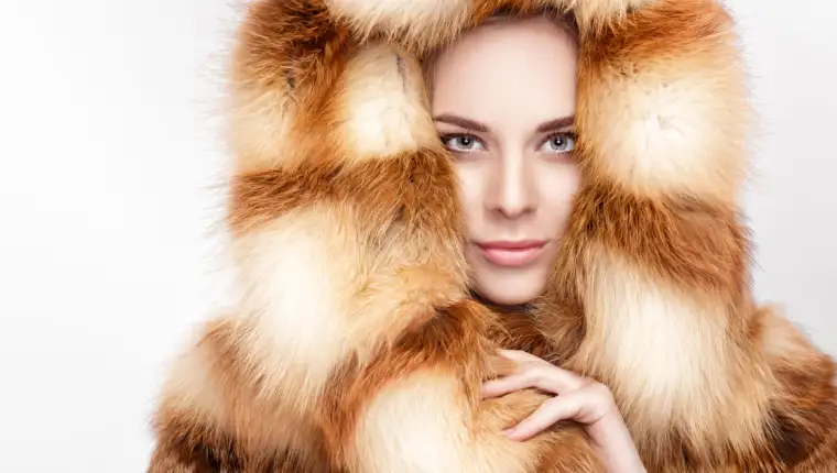portrait of beautiful young blonde woman in luxury Fox fur coat.