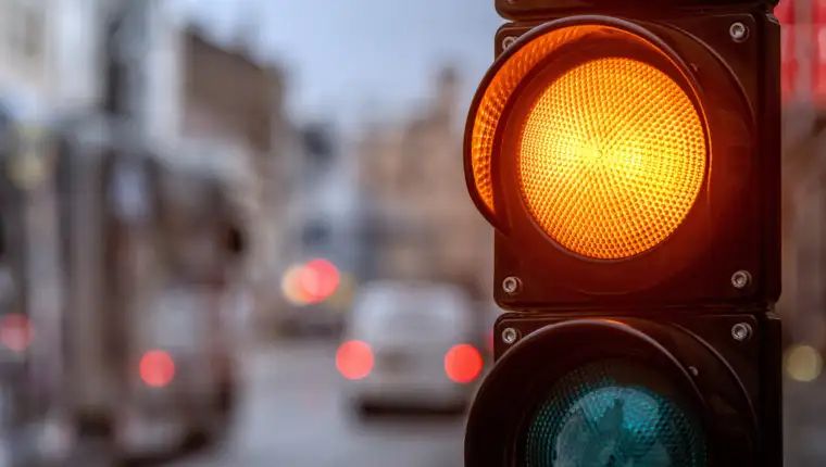 A city crossing with a semaphore. Orange light in semaphore - im
