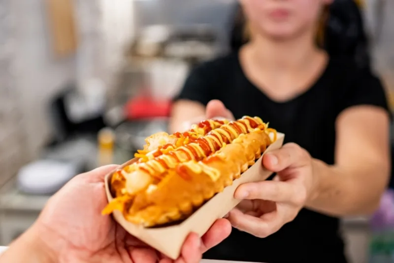 A,Close-up,Of,A,Hand,Holding,A,Hot,Dog,With
