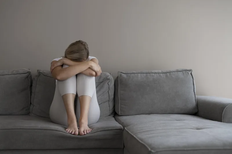 full-shot-woman-sitting-couch
