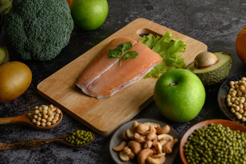 legumes, fruit, and Salmon fish pieces on a wooden chopping boar