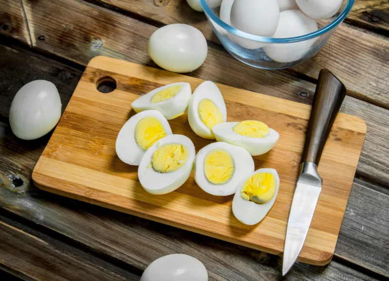 Sliced boiled eggs on cutting board.