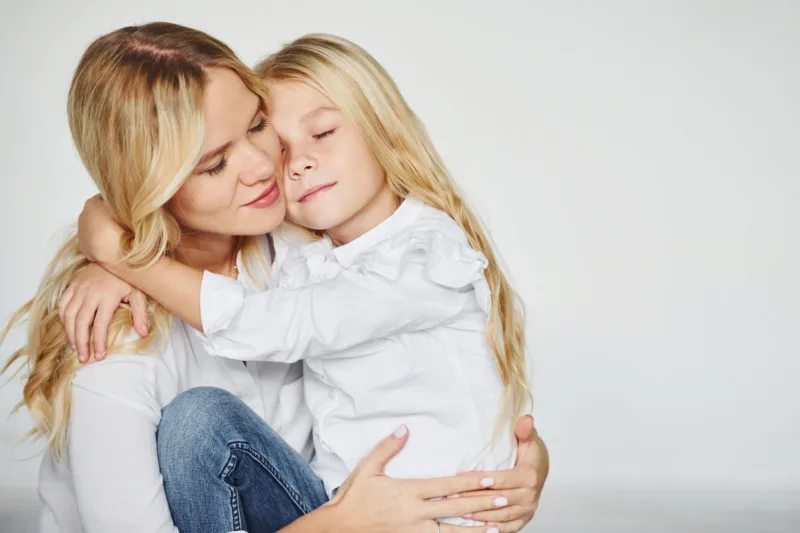 Mother with her daughter have fun together in the studio with white background