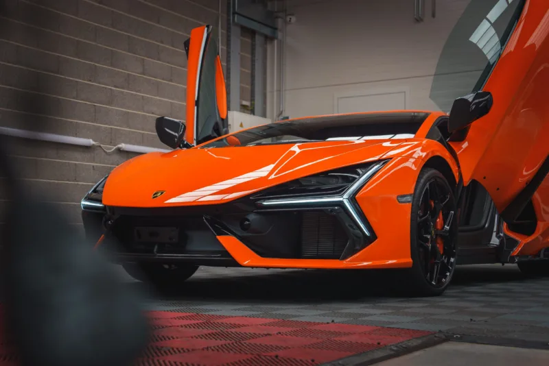 Orange Lamborghini Revuelto with Scissor Doors Open in Indoor Setting