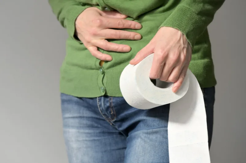 Woman Holding Her stomach And Toilet Paper Roll