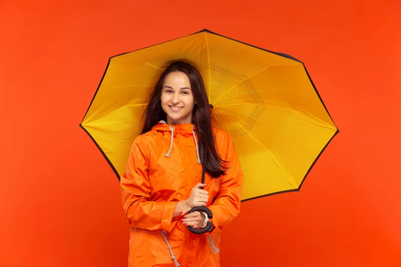 The young girl posing at studio in autumn jacket isolated on red