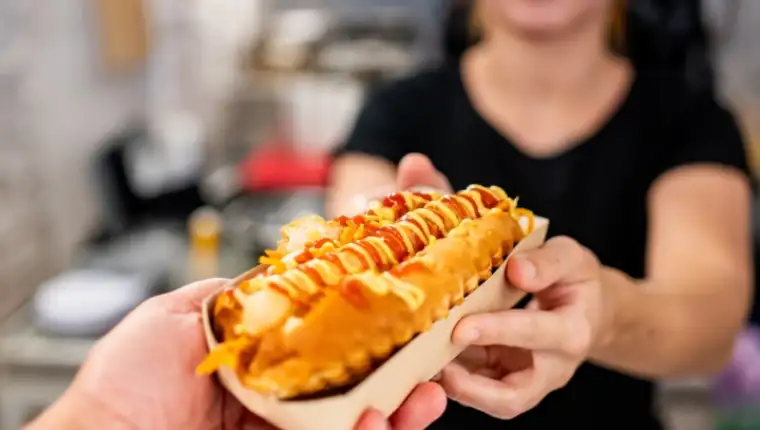 A,Close-up,Of,A,Hand,Holding,A,Hot,Dog,With
