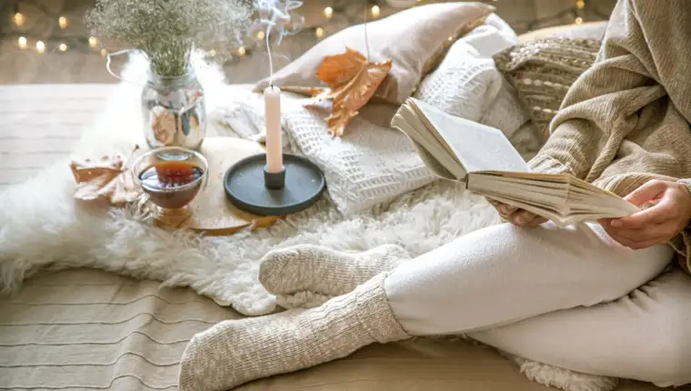 Cozy autumn at home, a woman with a book.