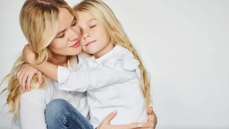 Mother with her daughter have fun together in the studio with white background