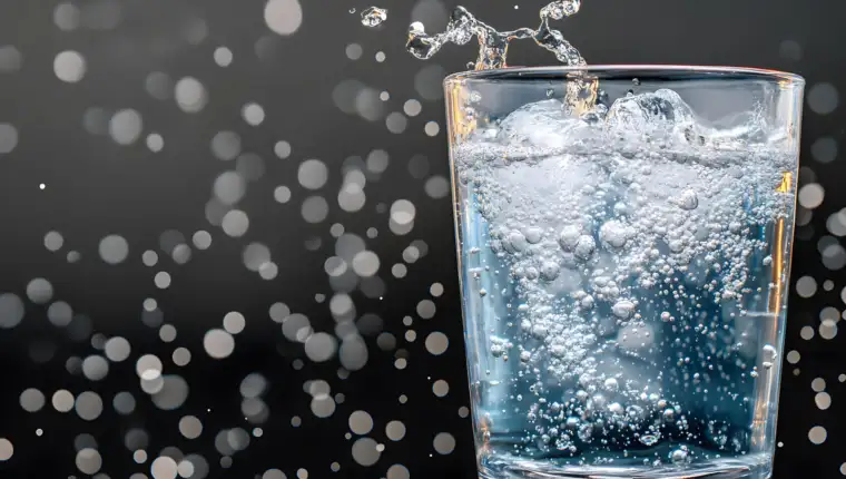 Sparkling water splashing in glass.