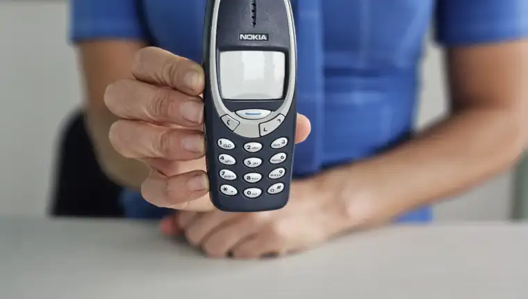 Minsk, Belarus, December 20, 2024 Businesswoman holding vintage phone nokia 3310 in hand concept