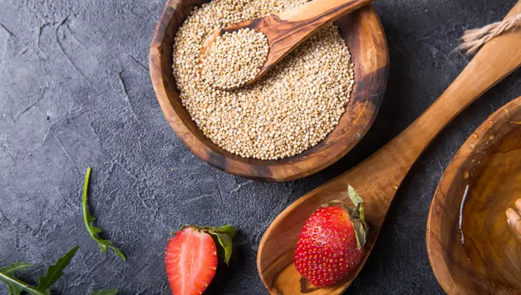 Quinoa White grains in a wooden bowl and spoon with strawberry,