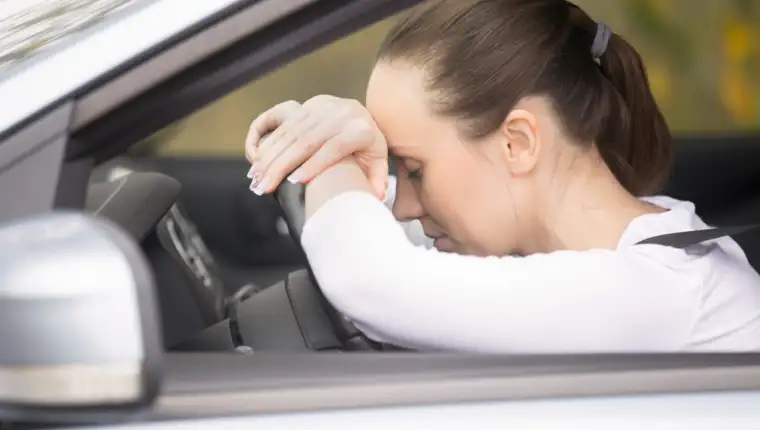 Young woman talking on her phone driving a car
