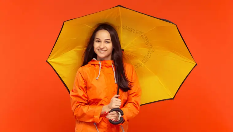 The young girl posing at studio in autumn jacket isolated on red