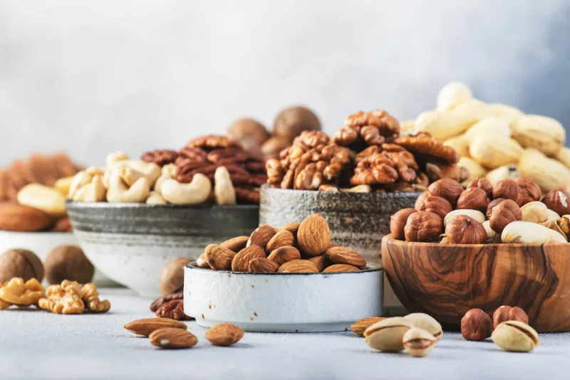 Assortment of nuts. Cashews, hazelnuts, walnuts, almonds etc. Healthy Food Snacks mix on gray background, copy space