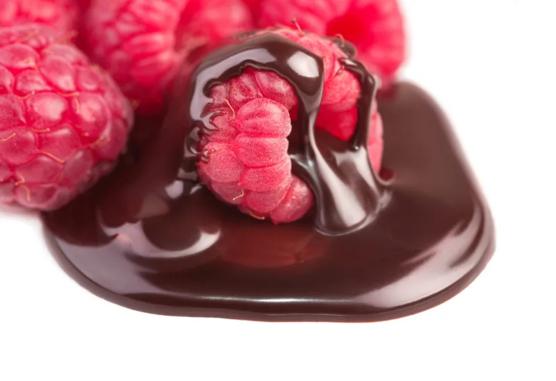 Raspberries in chocolate sauce on white