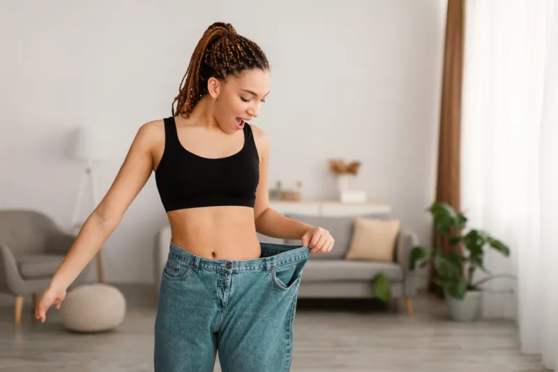 Black Female After Great Weight Loss Wearing Big Jeans Indoors