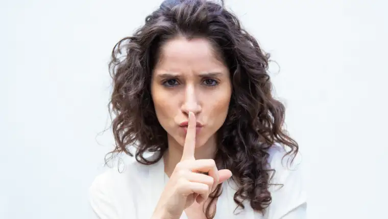 Strict beautiful woman making shh gesture