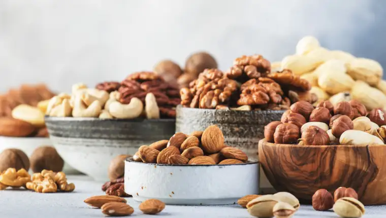 Assortment of nuts. Cashews, hazelnuts, walnuts, almonds etc. Healthy Food Snacks mix on gray background, copy space