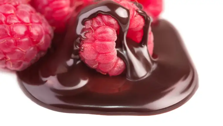 Raspberries in chocolate sauce on white