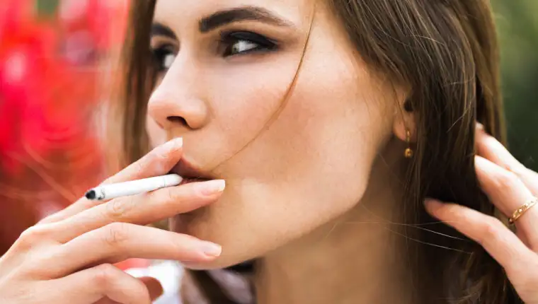 Brunette woman smokes a cigar