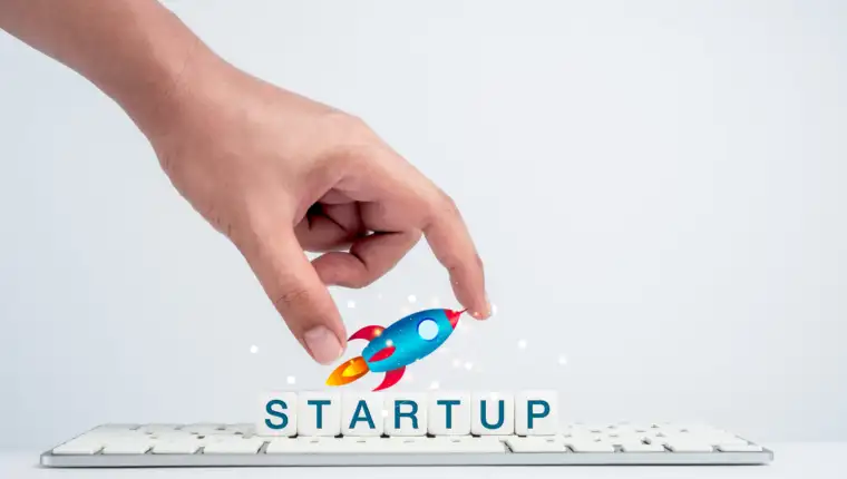 Startup concept. Hand holding rocket on white dice blocks.