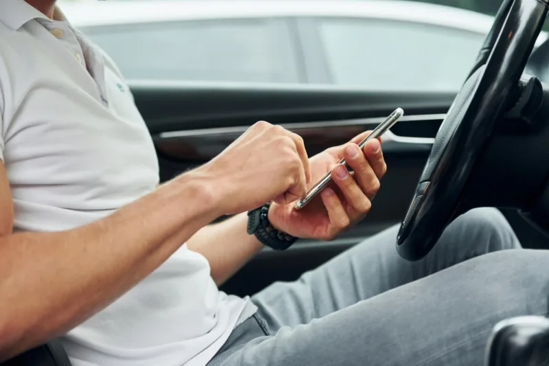vozač gleda u mobitel freepik