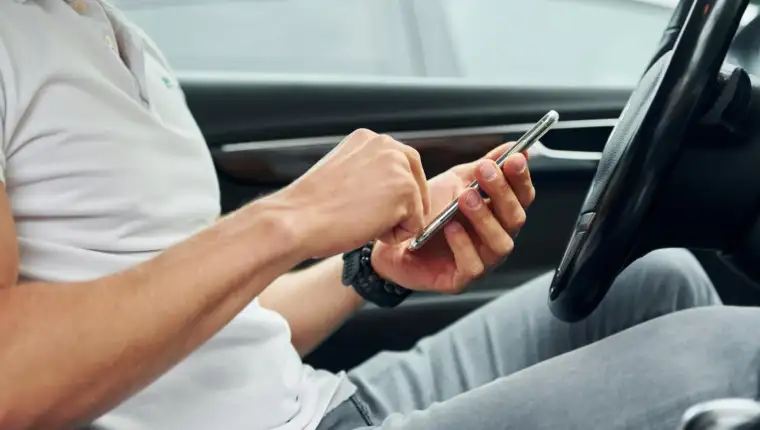 vozač gleda u mobitel freepik