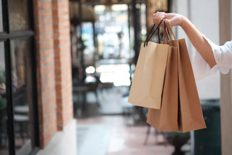 midsection-woman-holding-shopping-bags
