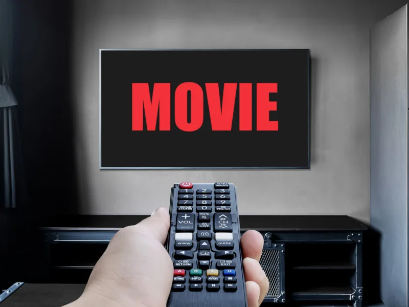 hand-hold-black-remote-control-television-with-red-text-movie-display-television-living-room