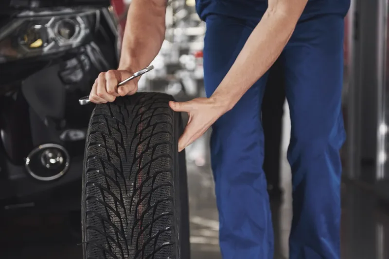 Close up of mechanic showing ok gesture with his thumb while holding a wrench