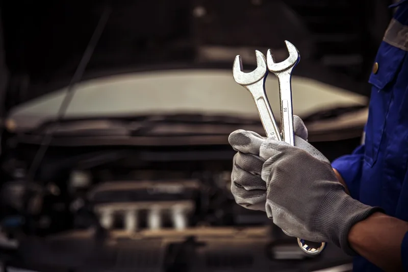 Close-up hand technician holding the wrench to repairing car