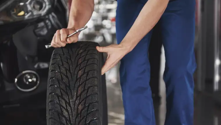Close up of mechanic showing ok gesture with his thumb while holding a wrench