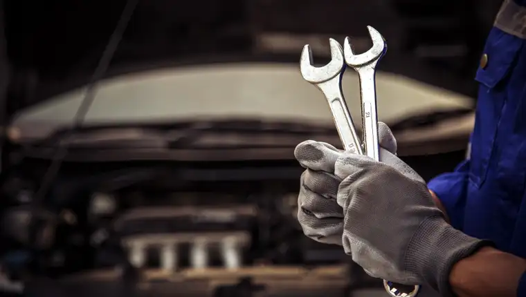 Close-up hand technician holding the wrench to repairing car