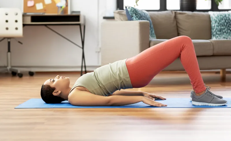 woman doing pelvic lift abdominal exercise at home