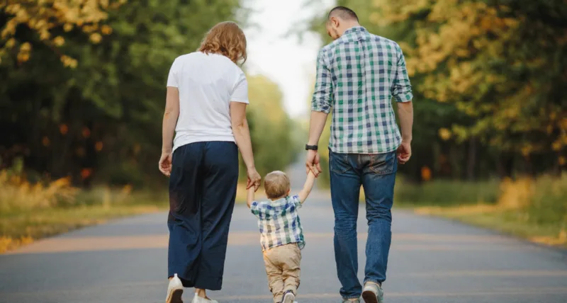 parents-holding-their-little-son-are-walking-road