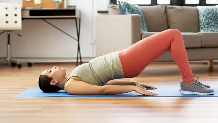 woman doing pelvic lift abdominal exercise at home