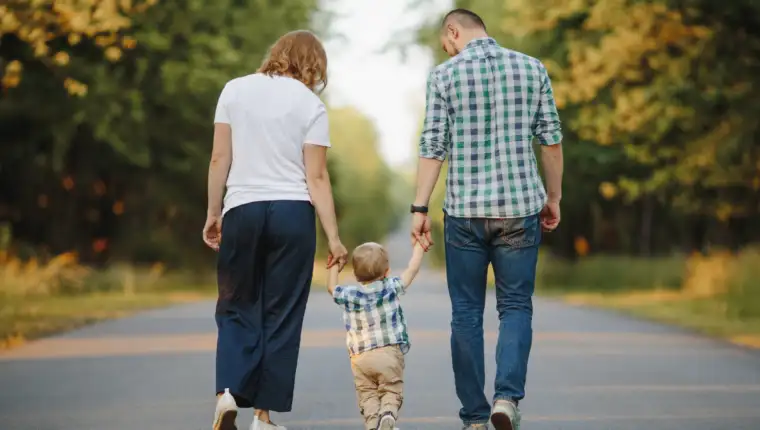 parents-holding-their-little-son-are-walking-road
