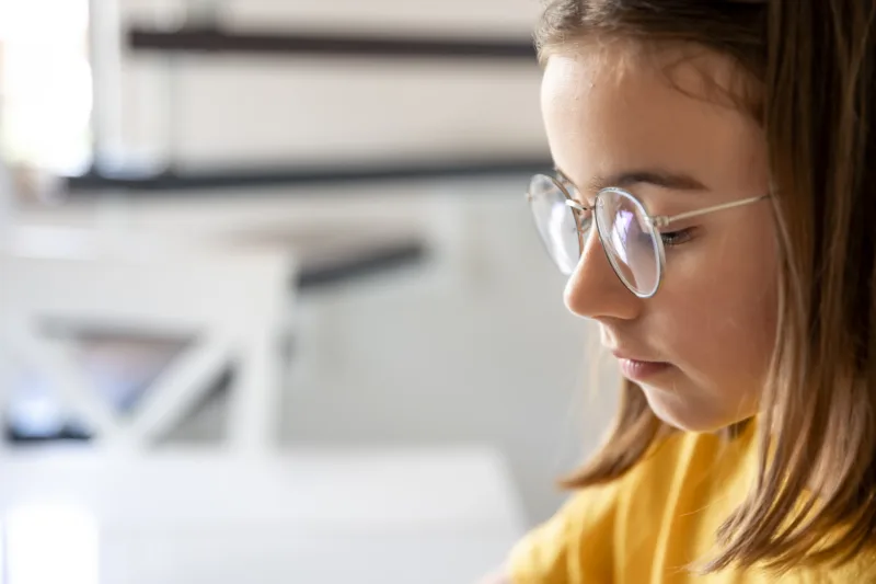 Teen girl glasses blurred background closeup
