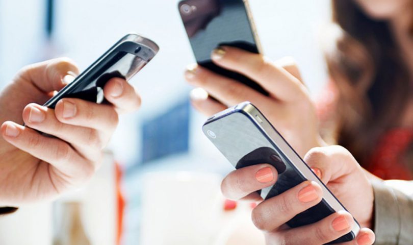 telefon zaražen malwareom troje ljudi u rukama drži mobitele