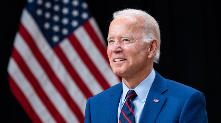 Biden ima 79 godina joe biden smije se i stoji pored američke zastave