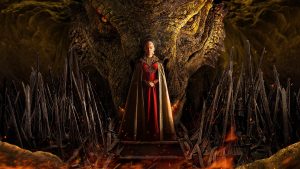 druga sezona Zmajeve kuće Rhaenys Targaryen stoji ispred zmaja u crvenoj haljini i zlatnom plaštu ruku sklopljenih na stomaku sa strana koplja sroji na postolju