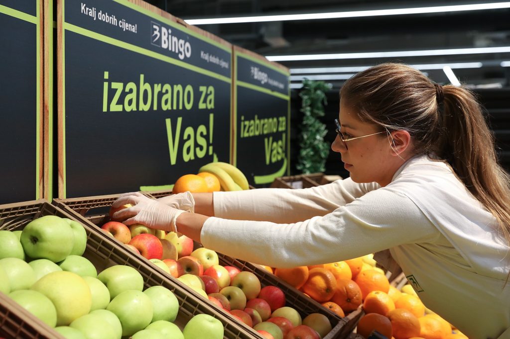 Plasman voća žena kupuje jabuke u marketu uzima voće s police