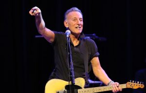 Bruce Springsteen pjeva na bini i drži gitaru u rukama