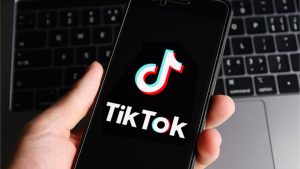 TikTok je postao globalna senzacija drži u ruci mobitel sa tiktok aplikacijom laptop