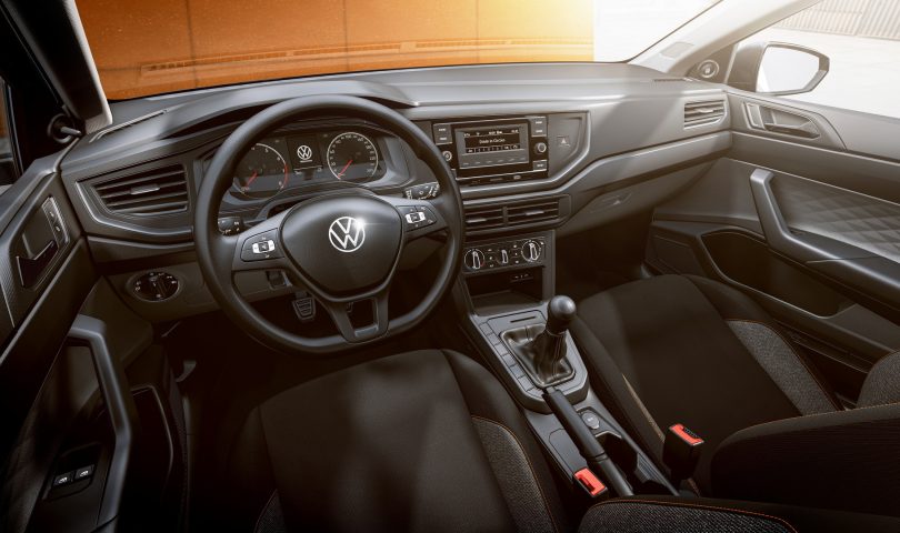Volkswagen ima novi model unutrašnjost automobila crna sjedišta znak Volkswagena na volanu vani smeđa podloga na kojoj je parkiran automobil