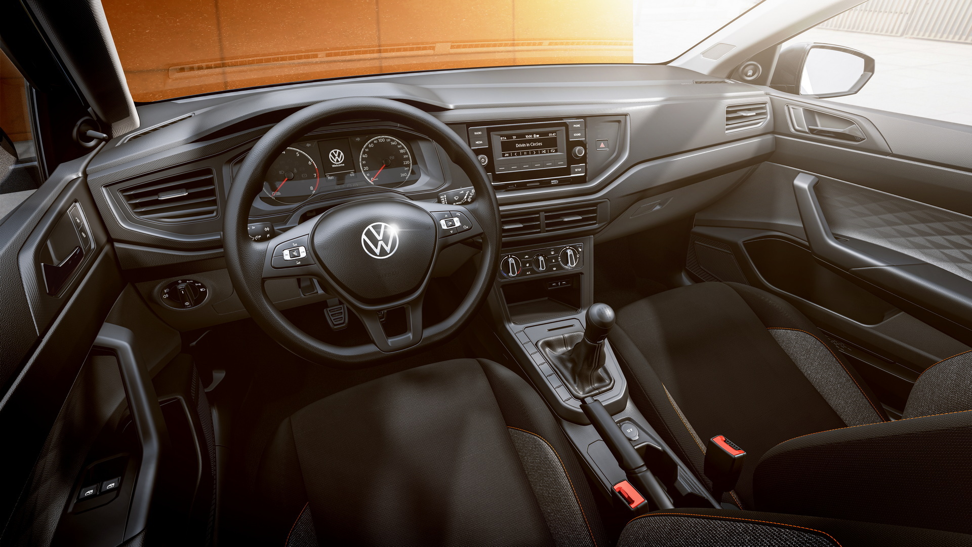 Volkswagen ima novi model unutrašnjost automobila crna sjedišta znak Volkswagena na volanu vani smeđa podloga na kojoj je parkiran automobil