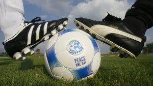 Adidas i Puma stari rivali kopačke na lopti jedna adisas jedna puma crnobijele na nogometnom terenu