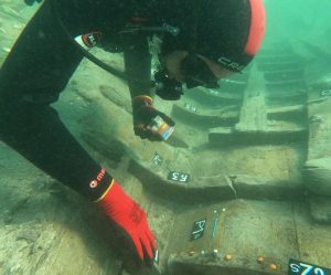 u Dalmaciji otkrili brod roniolac na morskom dnu u crnom ronilačkom odijelu sa crvenim detaljima na glavi i rukama označava brojem detalje broda voda bistra